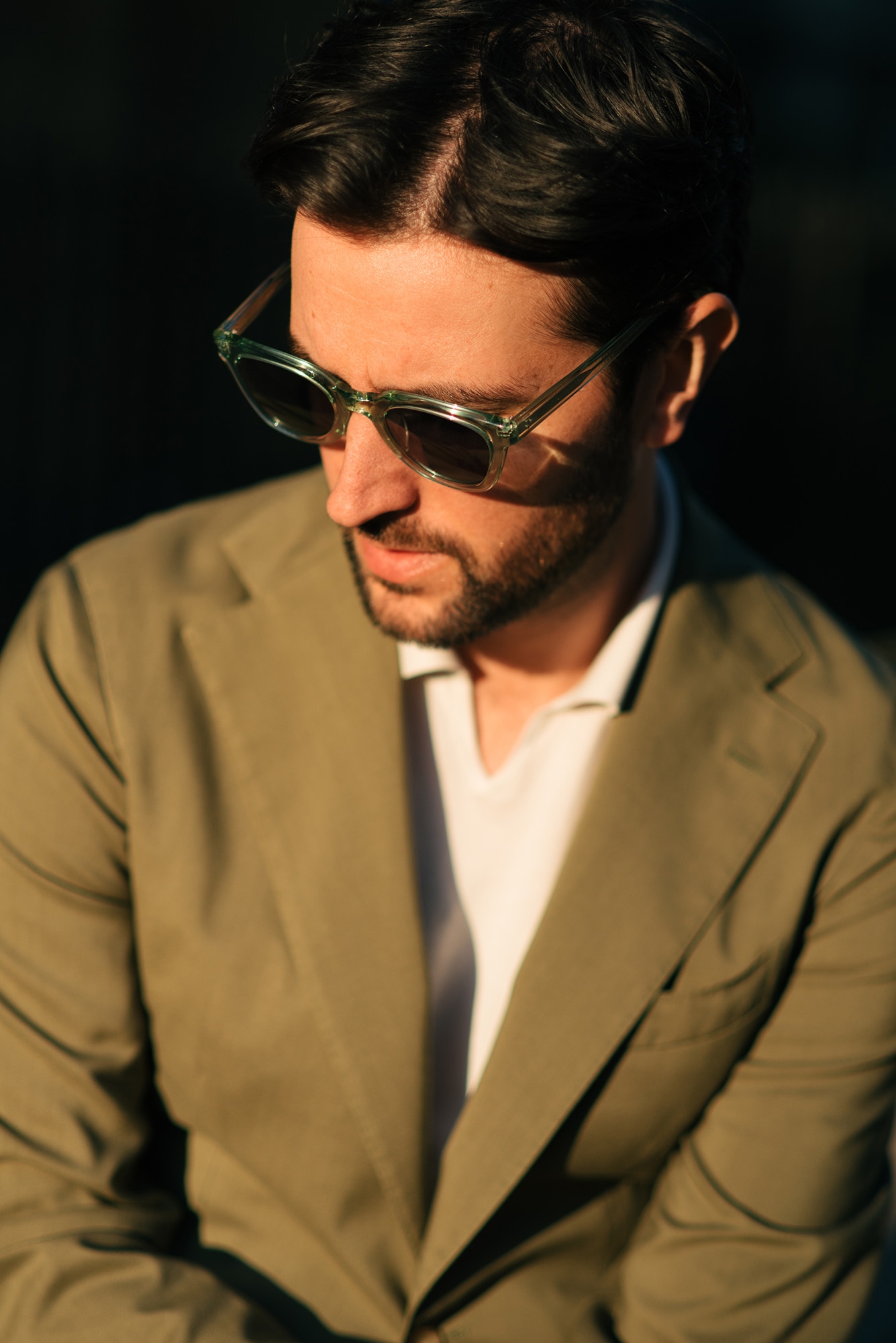 Man wearing a khaki blazer and sunglasses outside