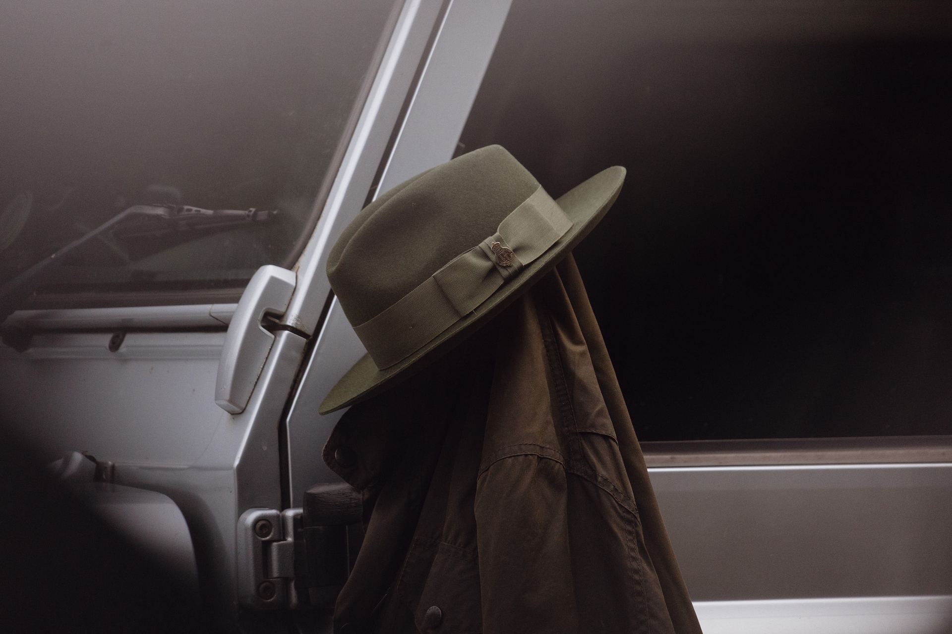 A green Christys’ hat and jacket hung on the side mirror of a Land Rover