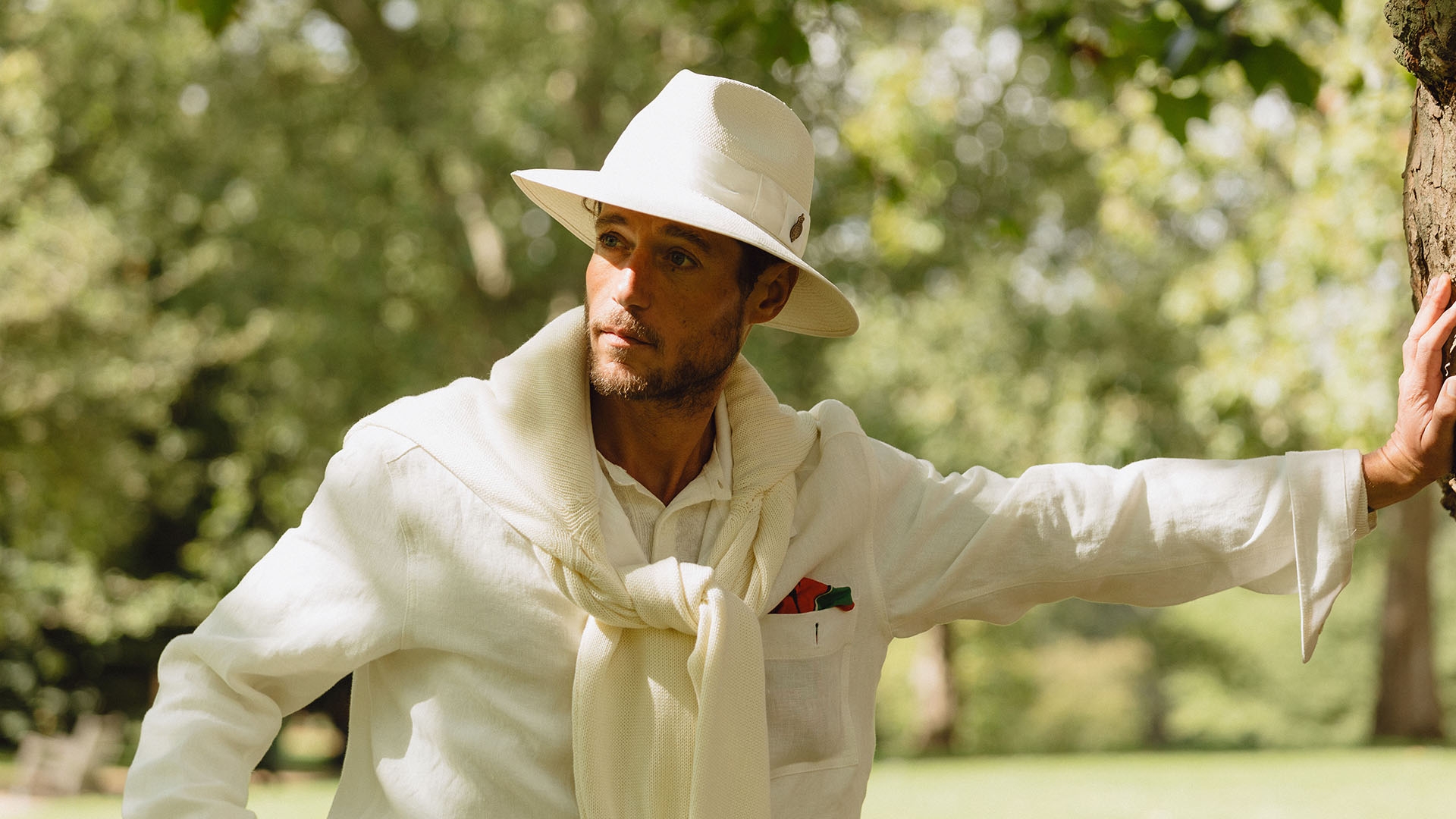 A man in a park wearing a Christys’ panama hat