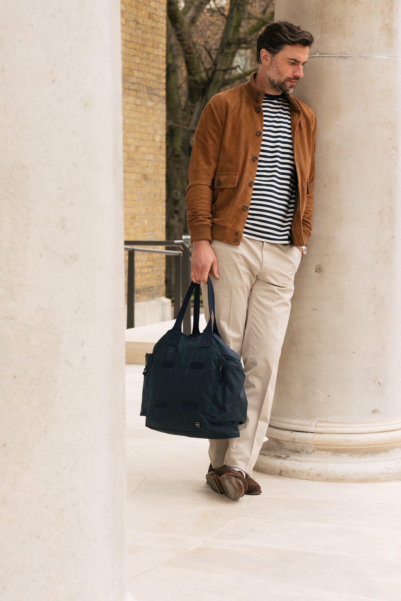 Man outside wearing Valstarino jacket and carrying a navy holdall