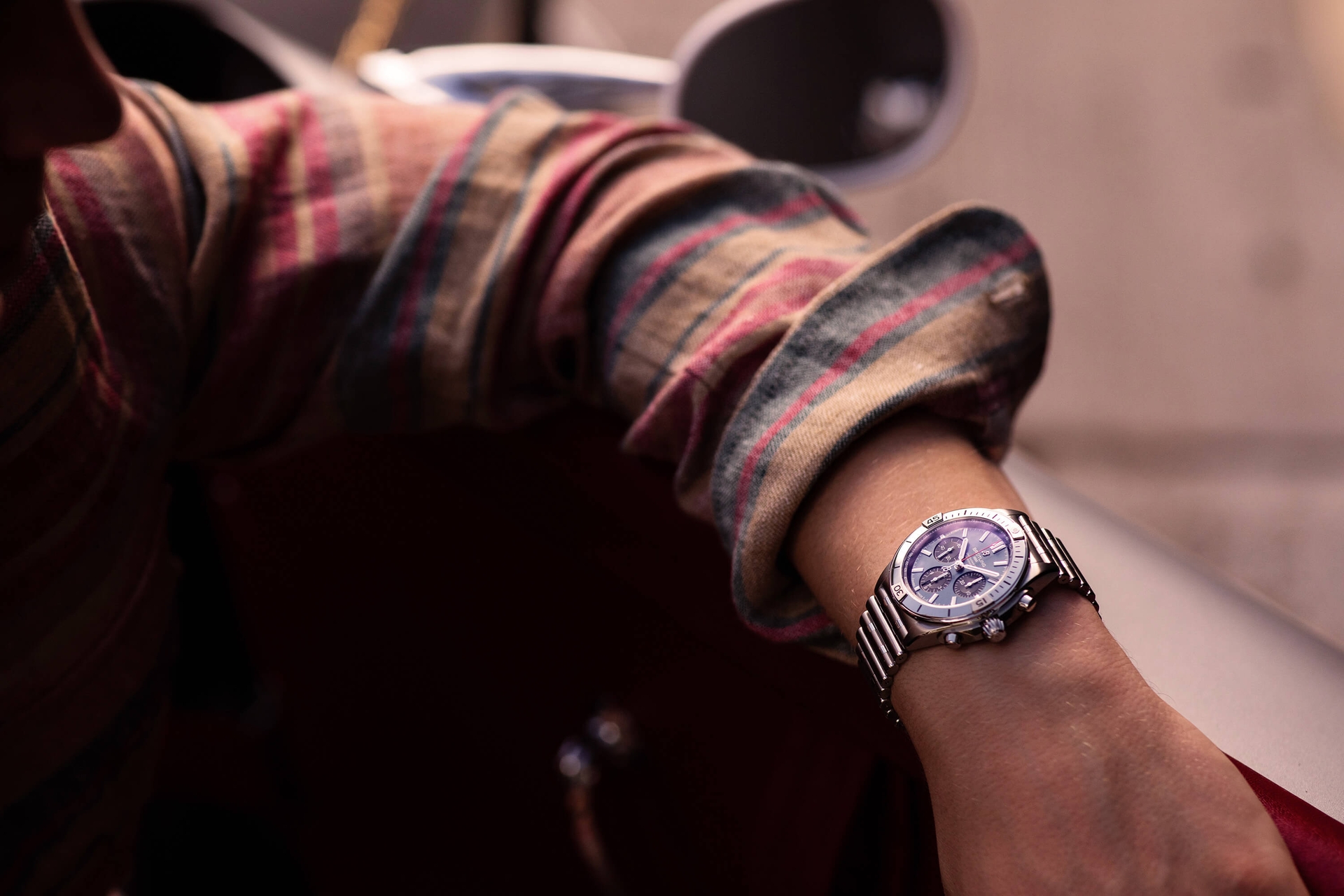 Man wearing striped shirt wearing Breitling watch